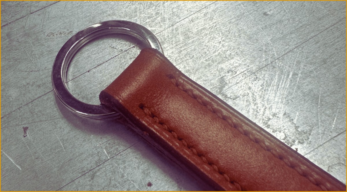 A close up of a keyring that has been made at the Walsall Leather Skills Centre. This is brown leather with brown colour matched stitching with a keyring.